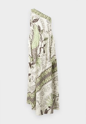 Žena nosi haljinu na jedno rame, dužine do poda, s zelenim i smeđim botaničkim uzorcima, u kombinaciji s crnim ravnim sandalama.