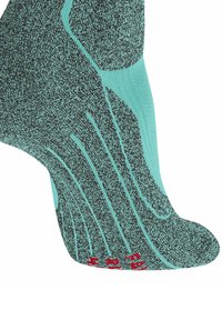 Turkusowa i czarna skarpetka kostkowa o teksturowanym wzorze z prążkowanym wykończeniem oraz czerwoną logotypem na palcu. Posiada wyściełane obszary dla komfortu i wsparcia.