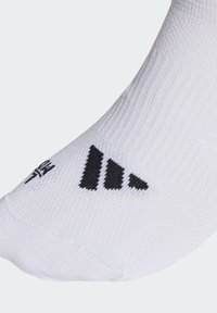 White athletic sock featuring a textured knit, with black three-stripe logo and heel accent. Ankle length, designed for comfort and support.