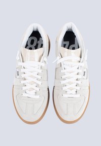 Sneaker bianche in suede con chiusura a lacci, suole in gomma naturale e colli imbottiti. Presentano dettagli in tessuto chiaro e il logo di lato.