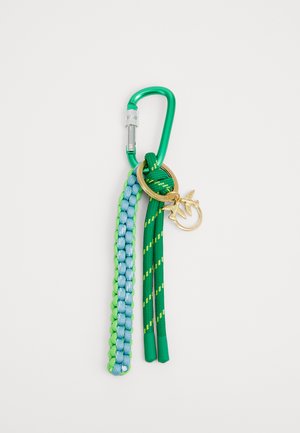 Mosquetão verde com fecho de segurança prateado. Estão anexadas três correias trançadas texturizadas em tonalidades de verde e azul, com um charme de pássaro dourado.