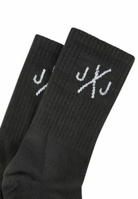 Black knitted socks featuring ribbed texture and a white logo design. The cuffs are elasticized for a secure fit.