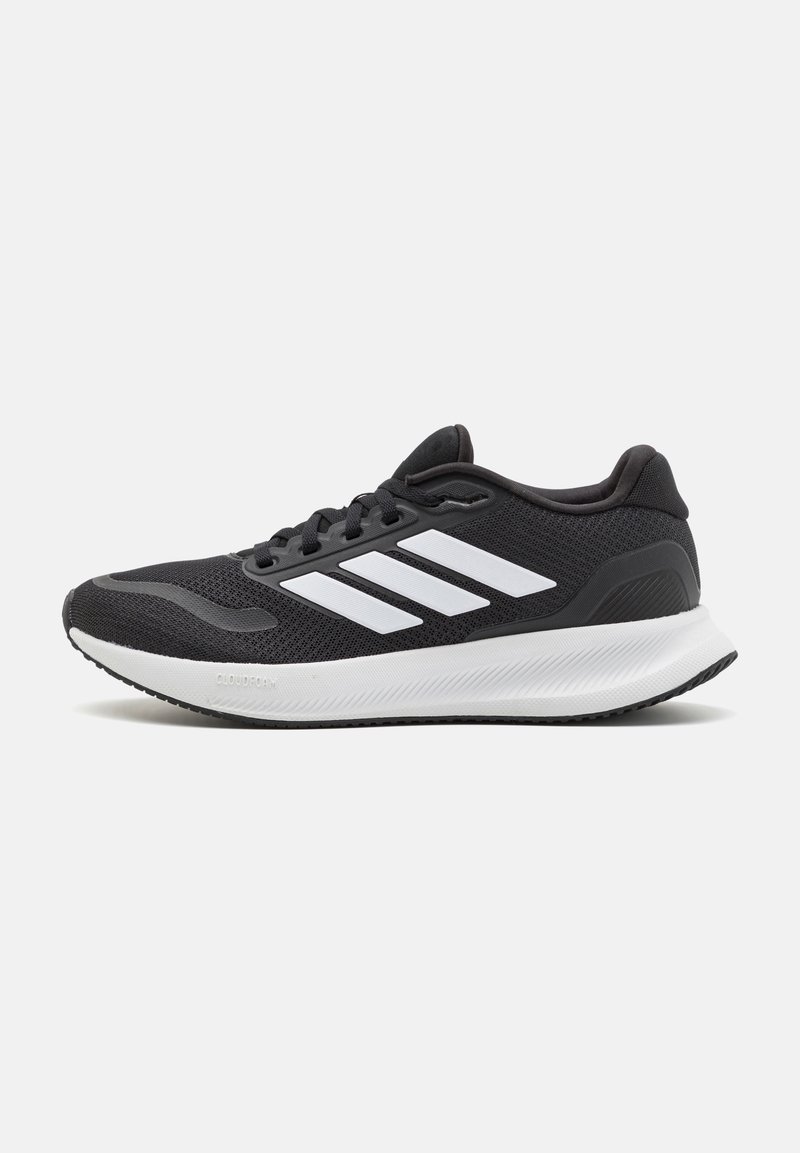 Baskets de sport noires avec semelle blanche et trois bandes blanches sur le côté, vues en profil droit sur fond blanc.