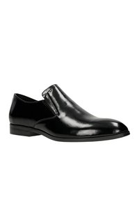 Černá kožená slip-on obuv s leštěným povrchem, zaoblenou špičkou, elastickými bočními panely a nízkým podpatkem. Jednoduchý design bez viditelných vzorů.