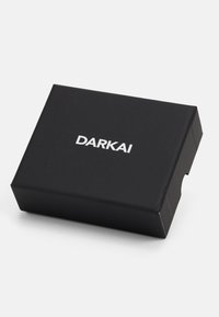 Caja rectangular negra con un acabado mate suave. Presenta la palabra "DARKAI" en letras blancas en negrita en la parte frontal.