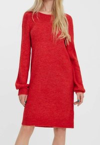 Robe-pull rouge à manches longues, encolure ronde et coupe décontractée. Fabriquée en matière douce et texturée, arrivant à mi-cuisse.