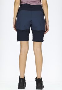 Shorts da escursionismo blu navy realizzati in un materiale elasticizzato e resistente all'acqua. Presentano zip su tasche e una vestibilità su misura in vita e cosce.