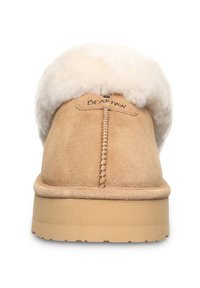 Beżowe zamszowe klapki z białym futrzanym mankietem, z przeszyciem wzdłuż środka oraz beżową gumową podeszwą zapewniającą przyczepność i komfort.