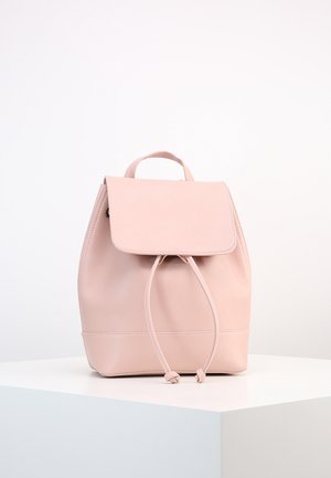 Sac à dos en cuir rose avec fermeture à rabat et cordon, présenté sur un piédestal blanc sur fond neutre.