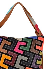 Sac en cuir porté épaule sur un fond noir avec des motifs géométriques colorés. Sangle double ton en marron, accents texturés.