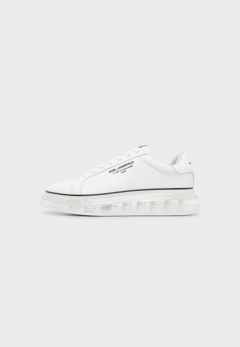 Baskets blanches Karl Lagerfeld avec logo texte noir et semelle épaisse transparente sur un fond clair uni.