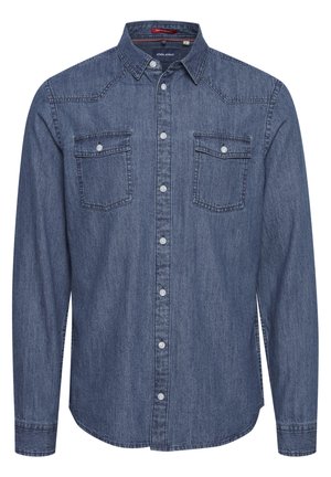 Blå denimskjorte med lange ermer, knapper i kragen, to brystlommer og kontrasterende sømmer langs skuldrene og knappeåpningen.