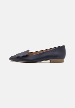 Navyblaue Leder-Ballettschuhe mit spitzem Zehenbereich, flachem Absatz und einer dekorativen Klappe im Obermaterial. Glatte Textur, minimalistisches Design.