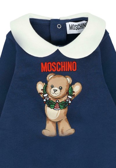 Abito per toddleri blu navy con colletto Peter Pan bianco, orsetto con una ghirlanda festiva, e "MOSCHINO" ricamato in rosso sopra.