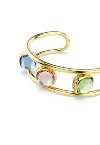 Bracciale a manica in tono oro con tre pietre preziose colorate: blu, rosa e verde, incastonate in bezel rotondi. Design morbido e curvo.