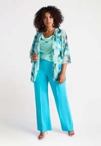 Een lichtgewicht, open voorkimono in een blauw-groene aquarelpatroon, gecombineerd met een teal-coloured schoudertop en bijpassende wijde broek.