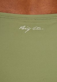 Olive green stretch fabric with a smooth texture, featuring stitched edges and a cursive "Big Star" logo in white.