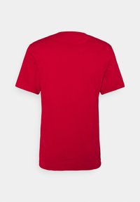 T-shirt in cotone rosso con maniche corte, colletto a giro e una texture liscia. Il retro è semplice, senza alcun motivo o grafica.