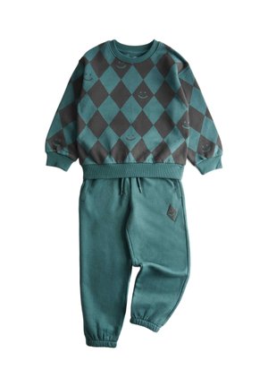 Sweat-shirt à motif losanges vert et gris foncé avec petits visages souriants, associé à un pantalon vert à taille élastique et poches resserrées avec une petite pièce à motif losange.