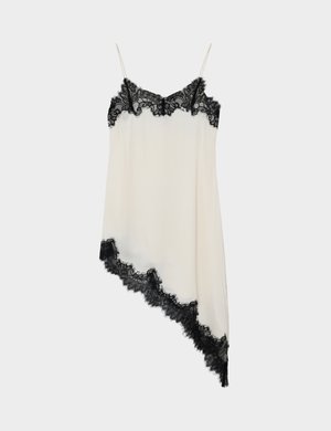 Kermansävyinen liivimekko, jossa mustat pitsikoristeet pääntiellä ja epäsymmetrinen helma, ohuilla spagettihihnoilla.