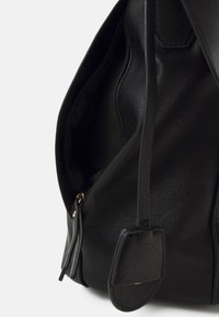 Borsa in pelle nera con una superficie liscia, dotata di chiusura con zip, forma strutturata e un accento di hardware dorato evidente.