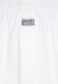 Boxer shorts bianchi in cotone con vita elasticizzata. Un'etichetta mostra "JOCKEY USA Originals" con una piccola bandiera americana.