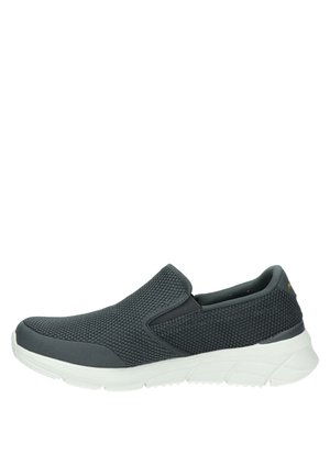 Zapatilla negra de malla con paneles laterales elásticos y suela gruesa blanca texturizada.