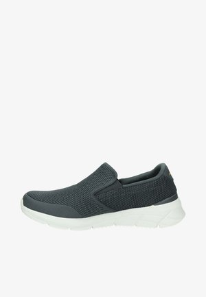 Zapatilla negra de malla con paneles laterales elásticos y suela gruesa blanca texturizada.