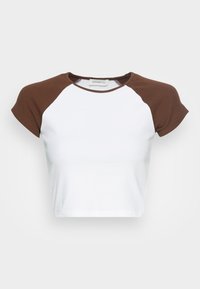 Vit kortärmad T-shirt med bruna raglanärmar och rund halsringning på en enkel bakgrund.