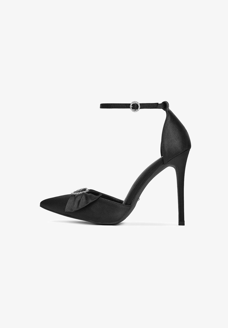 Pantof cu toc înalt din satin negru, cu vârf ascuțit, curea la gleznă, detaliu în formă de fundă pe partea superioară și accent de cristal pe curea. Toc subțire de tip stiletto.