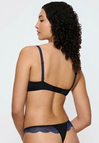 Conjunto de lencería negra con tirantes ajustables, con acentos de encaje en azul. Diseño simple, material suave y un borde festoneado en el tanga.