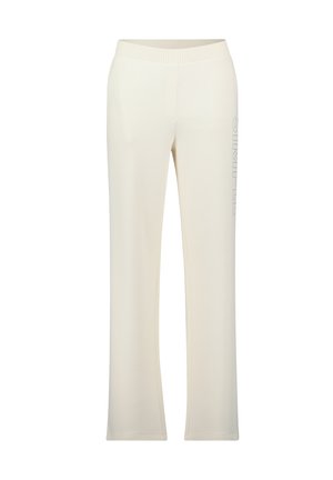 Crème-kleurige joggingbroek met een brede elastische tailleband, taps toelopende pijpen en verticale "SIMPLE" tekstdetail op het linkerbeen. Gladde textuur.