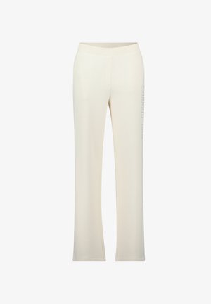 Crème-kleurige joggingbroek met een brede elastische tailleband, taps toelopende pijpen en verticale "SIMPLE" tekstdetail op het linkerbeen. Gladde textuur.