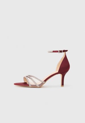 Dieprode sandalen met hak, voorzien van gekruiste mesh en versierde banden, open teen, slanke hak en enkelbandje.