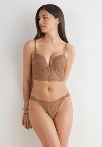 Brązowy koronkowy biustonosz braletka i pasujące stringi z kwiatowymi wzorami, falbaniastymi brzegami, regulowanymi ramiączkami oraz delikatnymi detalami.