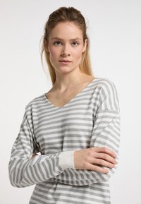 Csíkos, hosszú ujjú pulóver világosszürke és fehér színben. V-nyakú, laza fazonú, bordázott mandzsettákkal rendelkezik. Puha anyag, vízszintes csíkokkal.