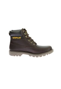 Bota de cuero marrón con cuello acolchado, parte delantera con cordones, marca "Caterpillar" en amarillo y suela de goma resistente con agarre texturizado.