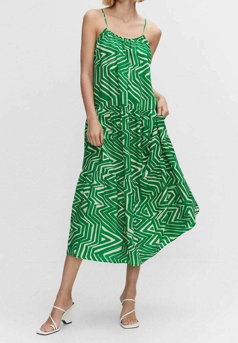 Robe maxi verte avec un motif en zigzag blanc, des bretelles spaghetti et une taille froncée pour une silhouette fluide.