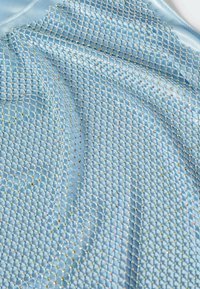 Tissu satin bleu clair arborant un motif en grille de petits strass multicolores, créant une surface texturée et scintillante.