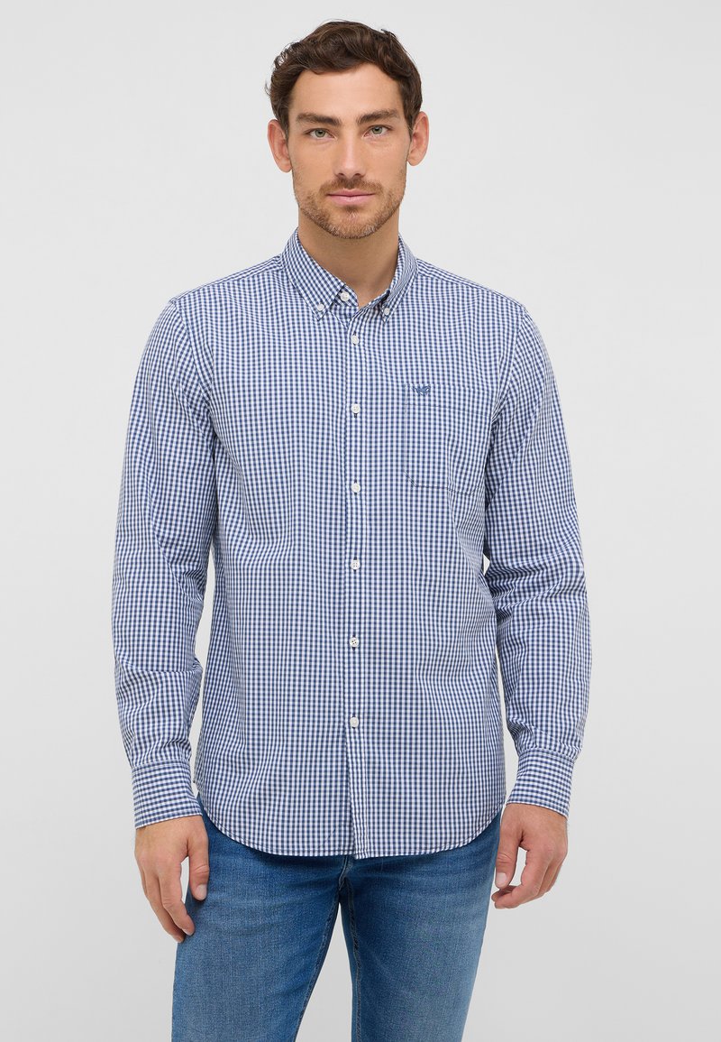 Chemise à carreaux bleu et blanc avec une poche, à manches longues et col. Fabriquée en tissu tissé avec une texture lisse.