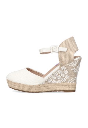 Cuña de espadrille blanca con parte superior texturizada y detalles de encaje floral. Presenta una correa de tobillo tejida en beige y una plataforma envuelta en yute.