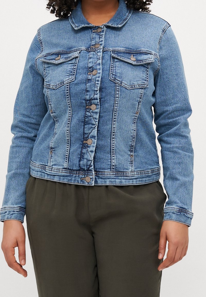 Veste en denim bleu clair avec un devant boutonné, des poches poitrine et des manches longues. Elle présente un col classique et de l�égers détails d'usure.