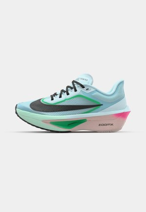 Light blue running shoe with a textured black mesh upper, green accents, a pink-tinged midsole, and a rubber outsole. Features laces and branding.