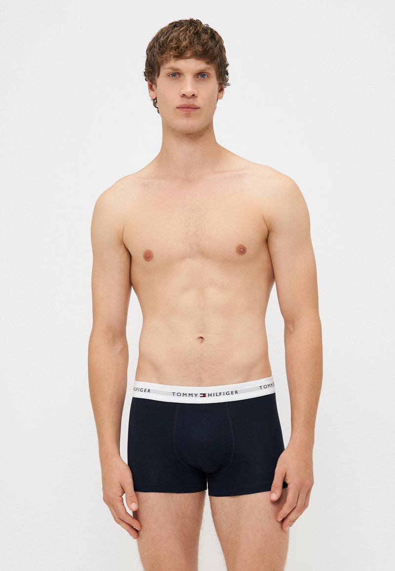 Sötétkék boxeralsó fehér derekú pánttal. A derékpánton fekete betűkkel szerepel a "TOMMY HILFIGER" márkaneve. Pamut anyag, testhezálló dizájn.