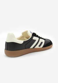 Czarno-kremowe sneakersy z teksturowaną skórzaną cholewką, wyraźnym białym numerem '70' oraz gumową podeszwą.