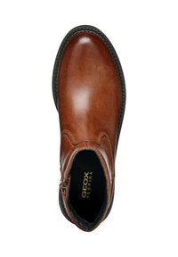 Brown leather ankle boot with a rounded toe, subtle stitching details, and a black rubber sole. Features a side zipper for easy wear.