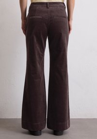 Bruine corduroy wijde broek met achterzakken, textuurstof en een nette zoom. De pasvorm is los van de taille tot aan de vloer.