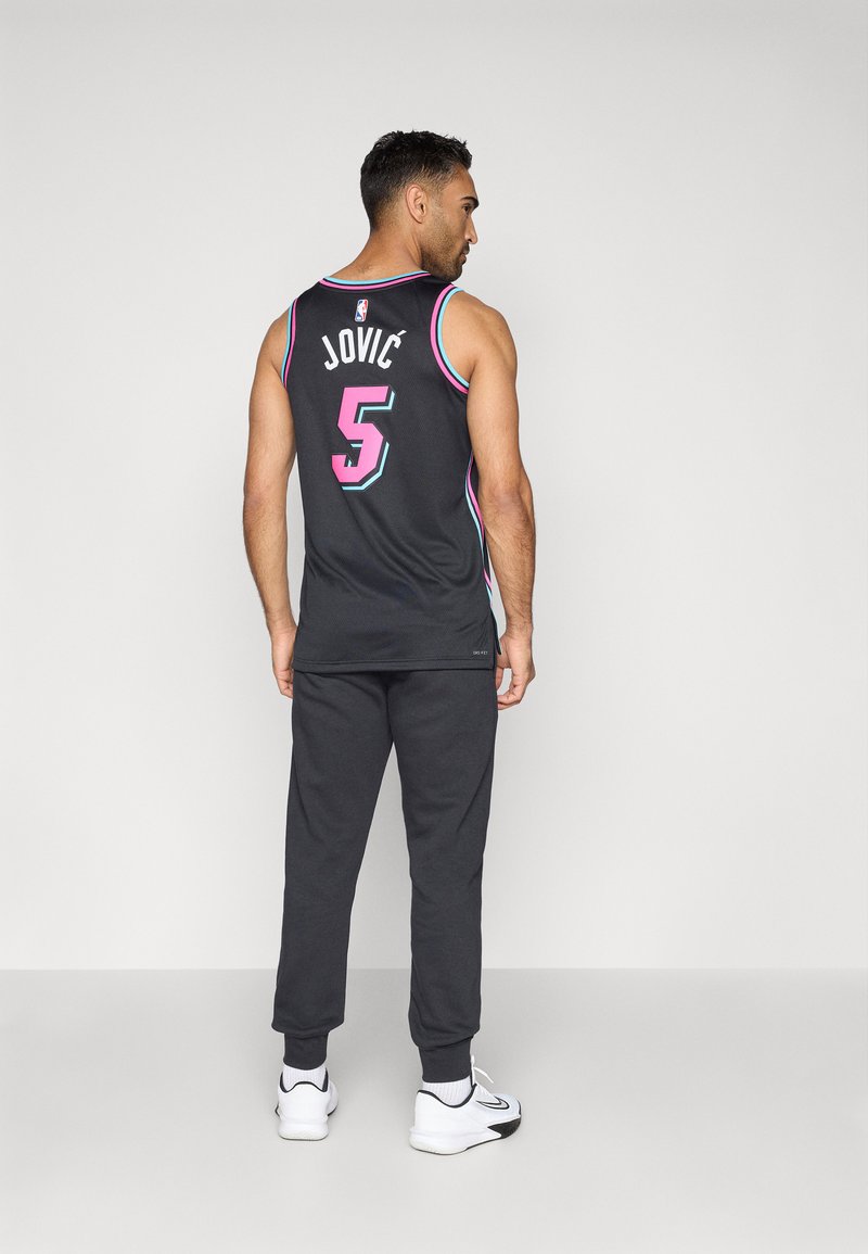 Schwarzes Basketball-Trikot mit rosa und blauen Akzenten, mit dem Namen "JOVIĆ" und der Nummer "5" auf dem Rücken. Kombiniert mit dunklen Trainingshosen und weißen Schuhen.
