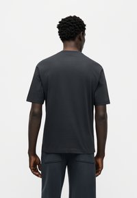 Μαύρο κοντομάνικο μπλουζάκι από μαλακό βαμβάκι με στρογγυλή λαιμόκοψη, διαθέτει άνετη εφαρμογή και μινιμαλιστικό σχέδιο, κατάλληλο για καθημερινή χρήση.