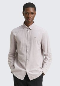 Lichtroze langemou shirt met een button-down kraag, voorzien van een subtiele geborduurde logo, gestructureerde stof en een gebogen zoom.